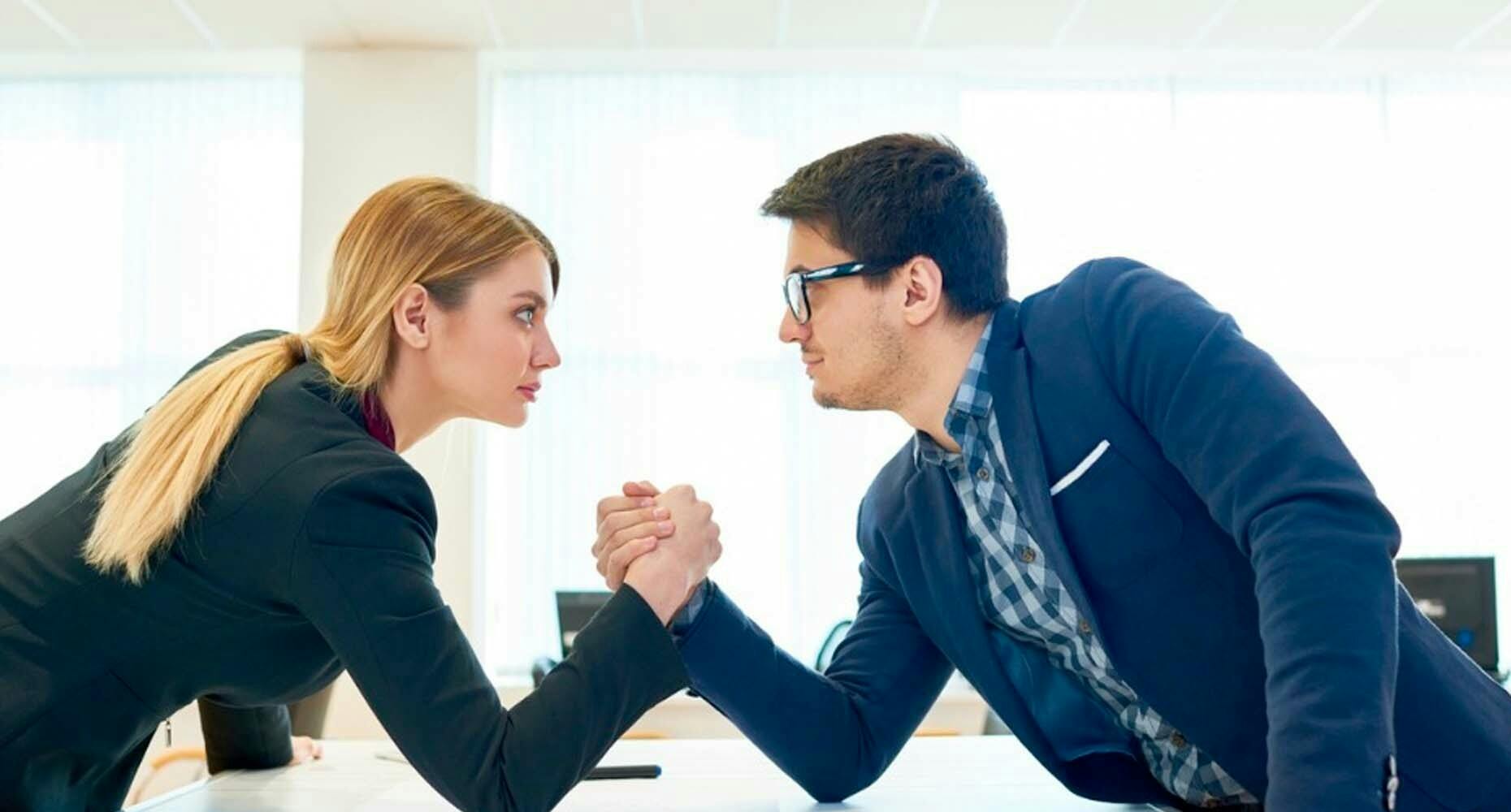 sales people arm wrestling in an office