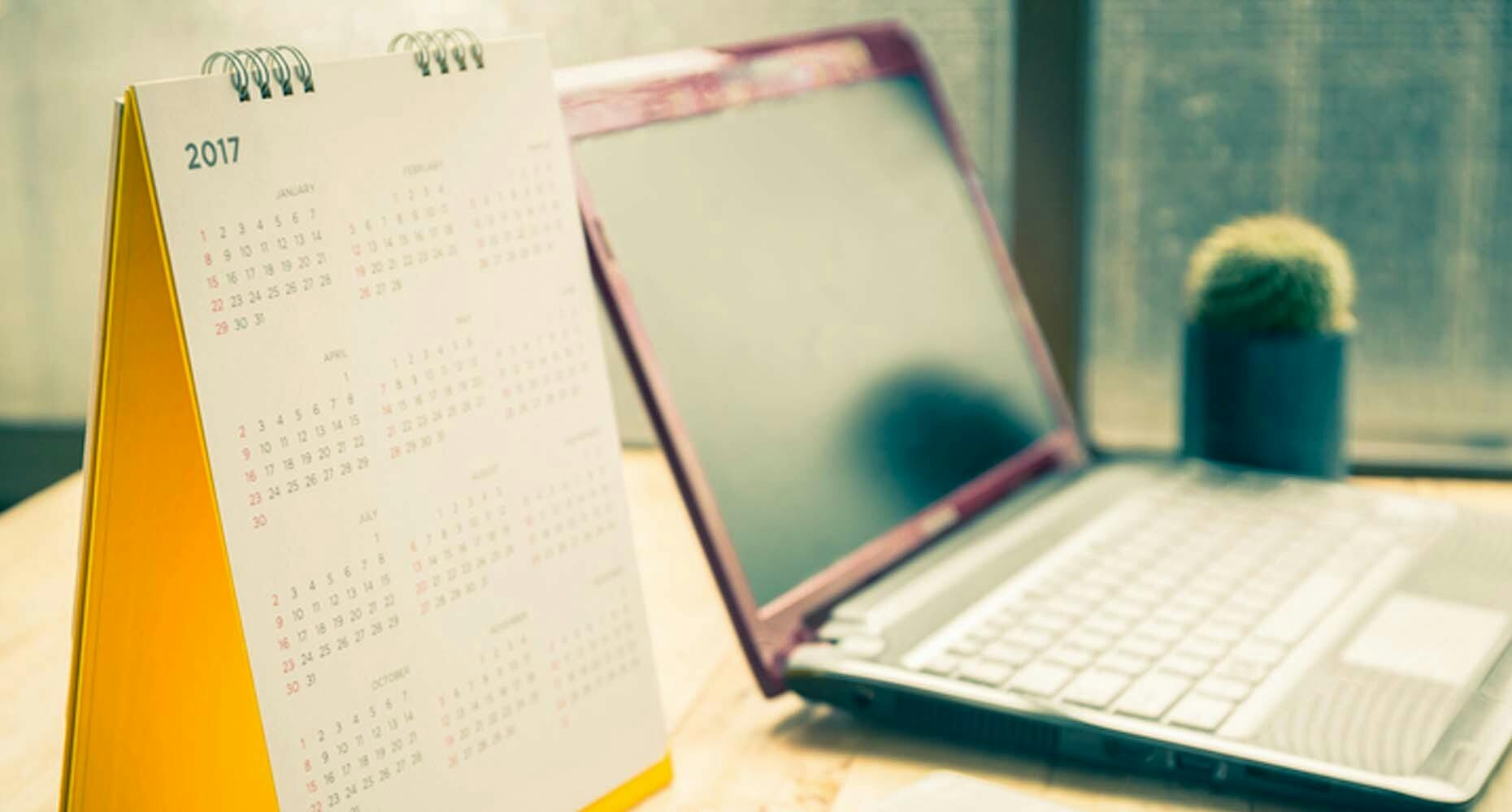 Calendar and laptop on a desk