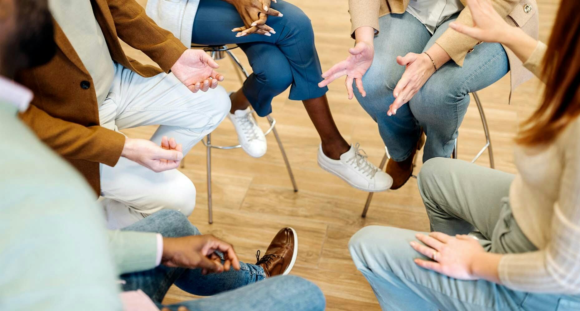 Group sitting on stools in a tight circle