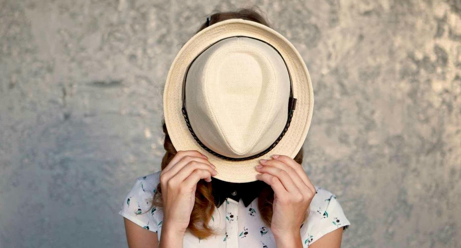 woman with hat covering her face