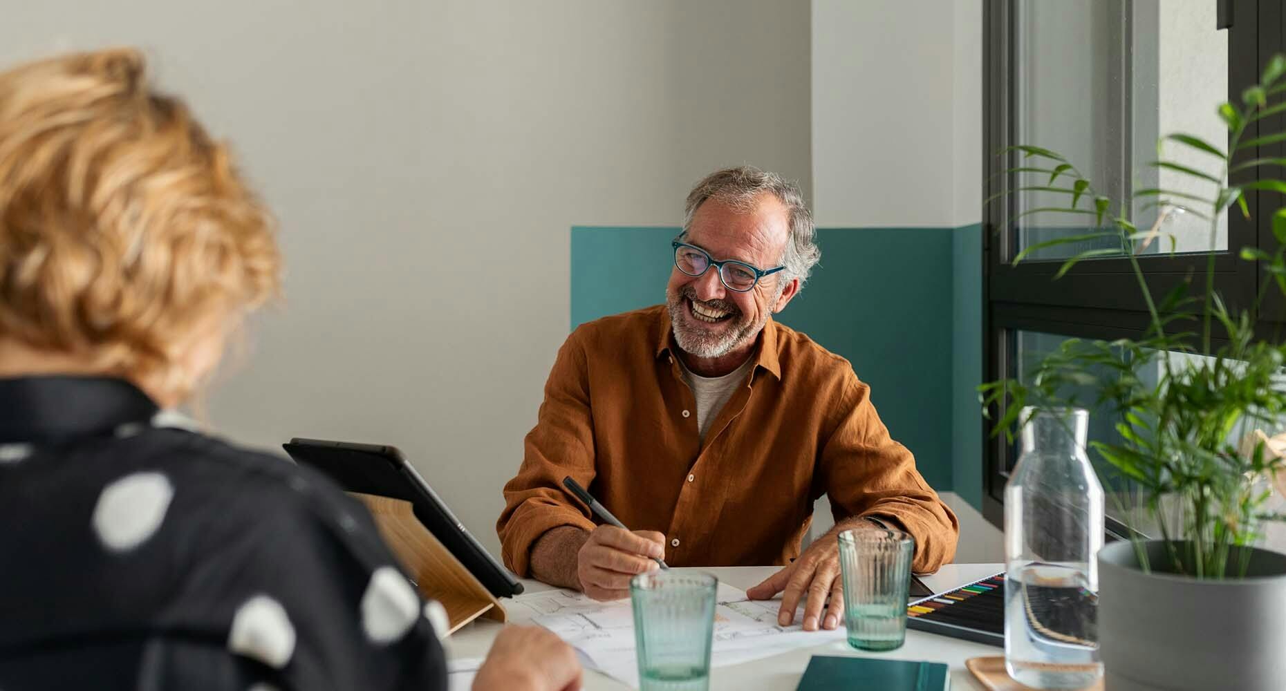 Man laughing at a conference table