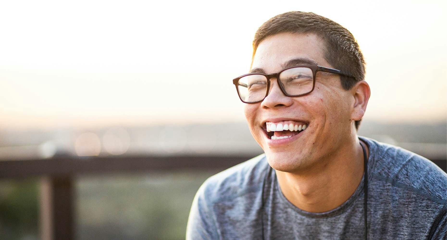 Man with glasses smiling outdoors