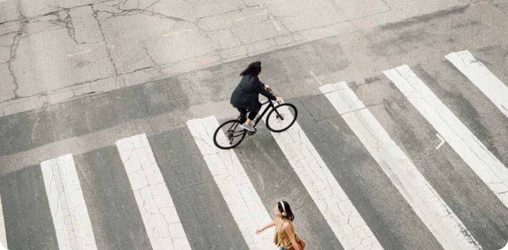 A woman riding a bike across a cross walk
